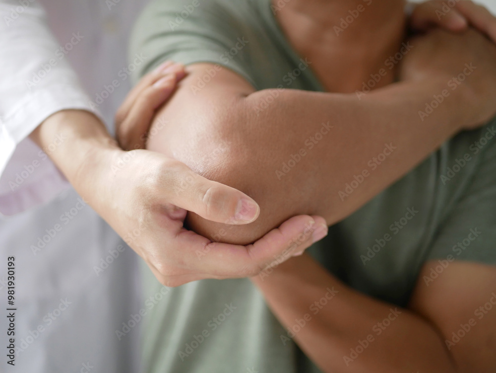 Asian male patient sitting doing physical therapy with female physiotherapist specialist doing pain therapy in hospital. Health concept Asian male patient sitting doing physical therapy with female physiotherapist specialist doing pain therapy in hospital. Health concept
