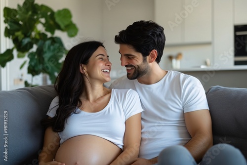 pregnant woman and her husband sitting on a sofa touching her belly and marveling at the baby's movements, concept of women's health, pregnancy planning, family life, poster for social problems