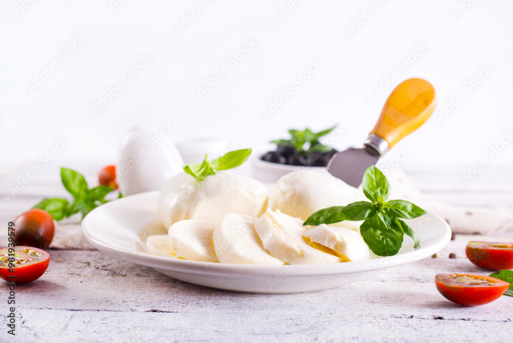 Large ball of mozzarella on white plate topped with herb oil Large ball of mozzarella on white plate topped with herb oil