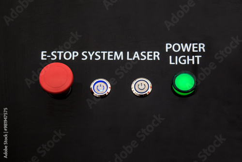 Black laser system control panel with buttons and power indicator and red emergency off button. photo