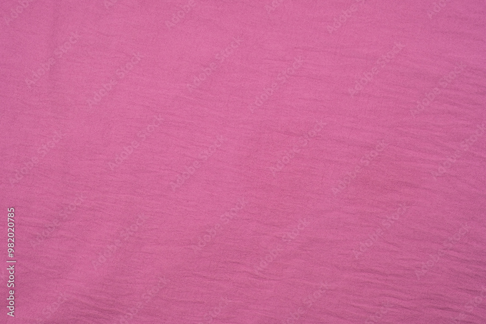 Fototapeta premium A vibrant pink fabric spread out on a flat surface, showcasing its texture and color