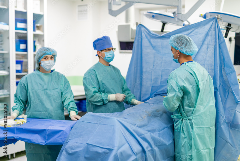Surgeons operating in a clinic. A surgical team works diligently, preparing for an operation in a clean, well-equipped medical facility during daytime hours. Surgeons operating in a clinic. A surgical team works diligently, preparing for an operation in a clean, well-equipped medical facility during daytime hours.