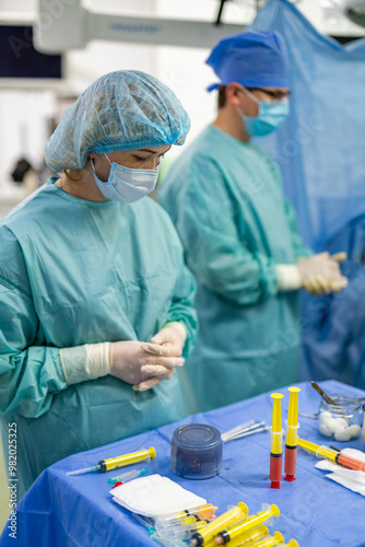 Surgeons getting ready in hospital. Two medical professionals in surgical attire focus on preparation before a procedure in a modern hospital setting.