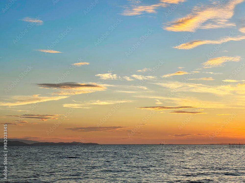 Fototapeta premium 幻想的な夕暮れ時の空と海に照らされる光