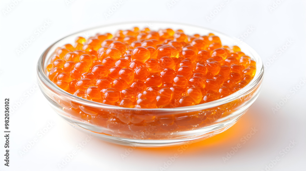 Close-up of salmon roe in a small dish, vibrant orange against the white Close-up of salmon roe in a small dish, vibrant orange against the white