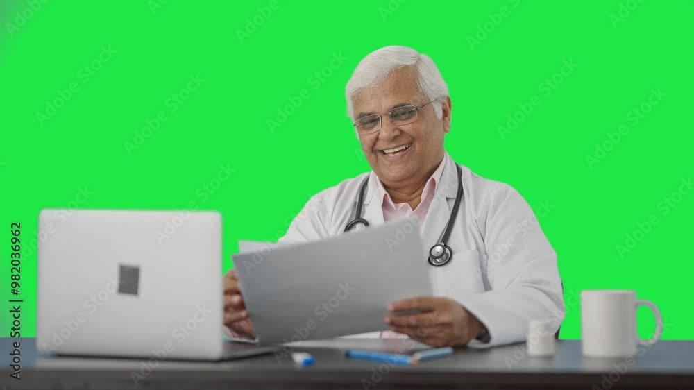 Happy Indian senior doctor reading health reports Green screen Happy Indian senior doctor reading health reports Green screen