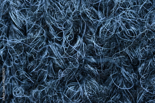 macro texture of woolen dark gray fluffy sweater, warm crocheted fabric as background, close up of gray crocheted front surface, texture of woolen wool, crocheted front surface photo