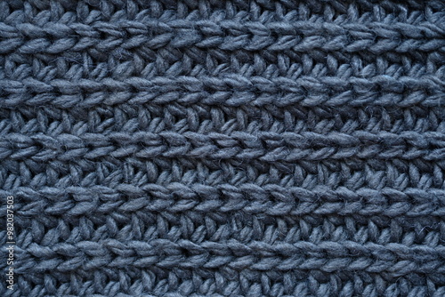 macro texture of woolen dark gray crocheted sweater as background, close-up of gray crocheted front surface, woolen texture of woolen wool, knitted front surface