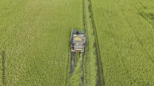07,09,2024 Lopburi, Thailand, Thai farmers harvest their crops using a modified tractor equipped with rice harvesting machinery in a rice field in Thailand.