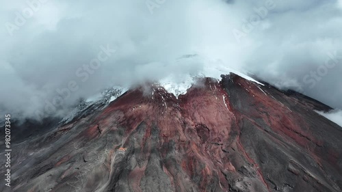 Snowy Cotopaxi volcano peak, Andes in Ecuador. Aerial drone lateral view and sky for copy space