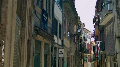 A narrow street view of Porto with balconies and laundry etc.