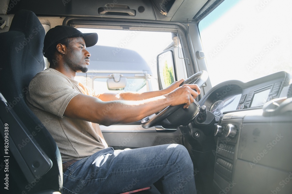 Naklejka premium Professional driver sitting in truck cabin and driving