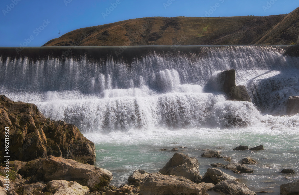 Obraz premium artificial waterfall on a dam on the Lepsy River in Kazakhstan in summer.