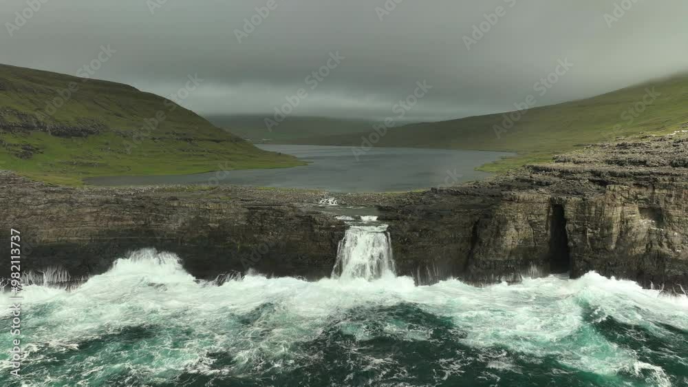 Aerial Flying Towards the Lake Above The Ocean, Sorvagsvatn Waterfall in Vagar, Faroe Islands on a Cloudy Day Aerial Flying Towards the Lake Above The Ocean, Sorvagsvatn Waterfall in Vagar, Faroe Islands on a Cloudy Day
