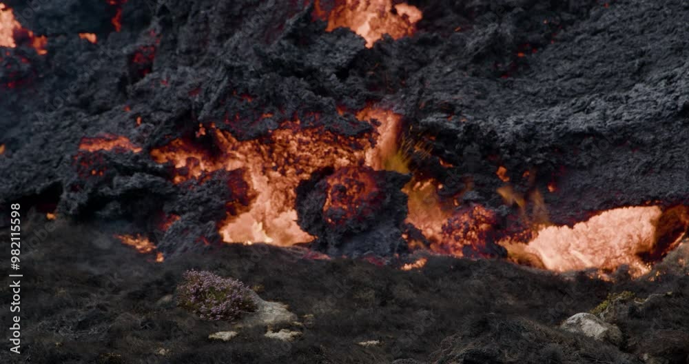 Close-up of molten lava slowly flowing from Grindavik volcano in Sundhnúkur crater, Iceland. Close-up of molten lava slowly flowing from Grindavik volcano in Sundhnúkur crater, Iceland.