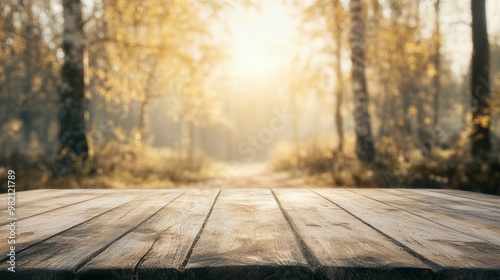 Wooden table in front of a beautiful autumn forest, sun rays shining through the trees, perfect for outdoor and nature backgrounds. photo