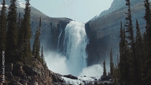 Massive spray from a waterfall cascading down a huge stone wall in the Canadian Rockies photo