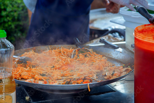 Cooking street food in Thailand. A traditional Thai dish called pad thai. Fried rice noodles in a pan. Asian pad thai noodle cooking process on the streets of Thailand