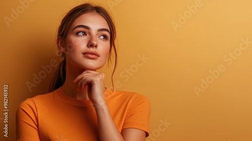 A woman in an orange shirt is looking to her left