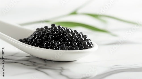 Close-Up of Black Caviar in a Spoon on Marble Background photo