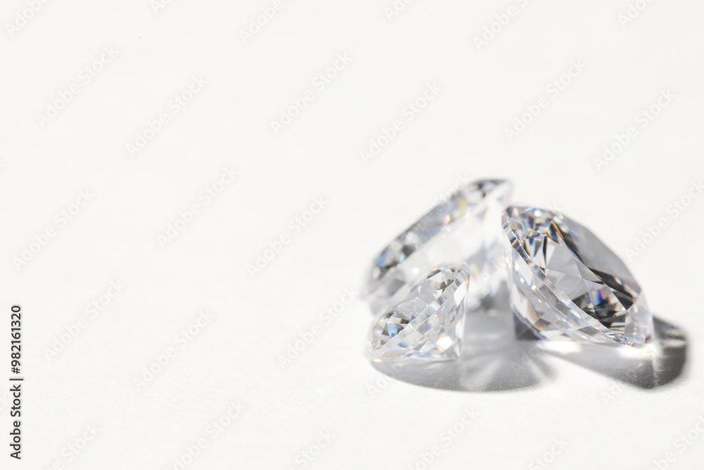 Two beautiful shiny diamonds on white background, closeup. Space for text Two beautiful shiny diamonds on white background, closeup. Space for text