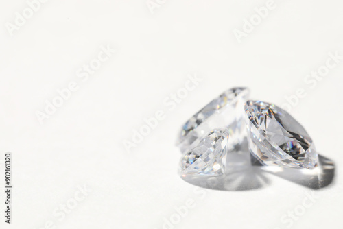 Two beautiful shiny diamonds on white background, closeup. Space for text