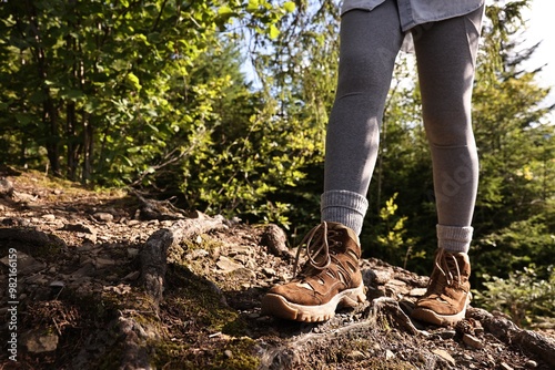 Young hiker wearing trekking shoes outdoors, closeup