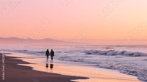 Silhouettes of a couple walking hand-in-hand along a sandy beach with the pink sunset in the background.