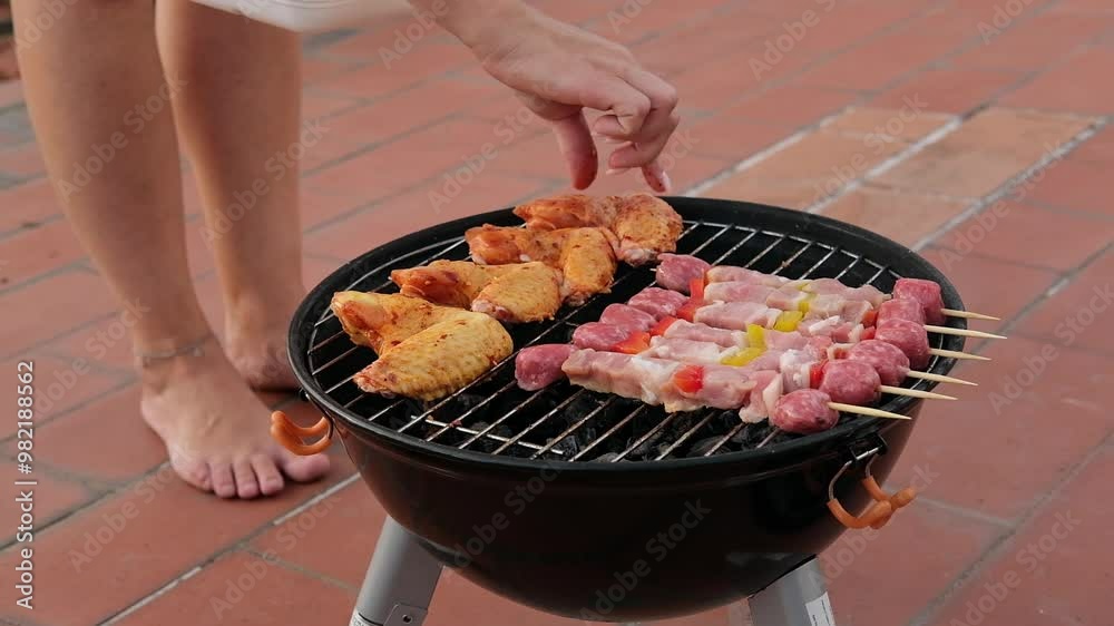 woman cooking grilling sweet corn and meat kebabs and chicken wings on the home terrace on a charcoal grill, Barbecue Grill