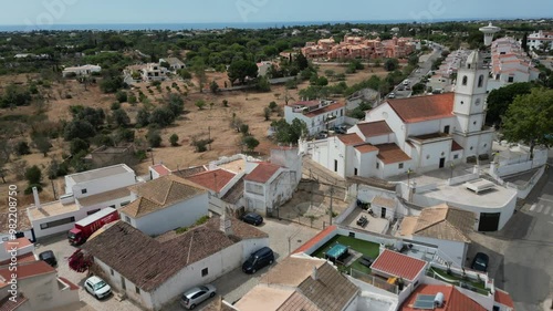 Beautiful drone shot over the portugal village of Porches with white church and dry landscape while flying forward photo