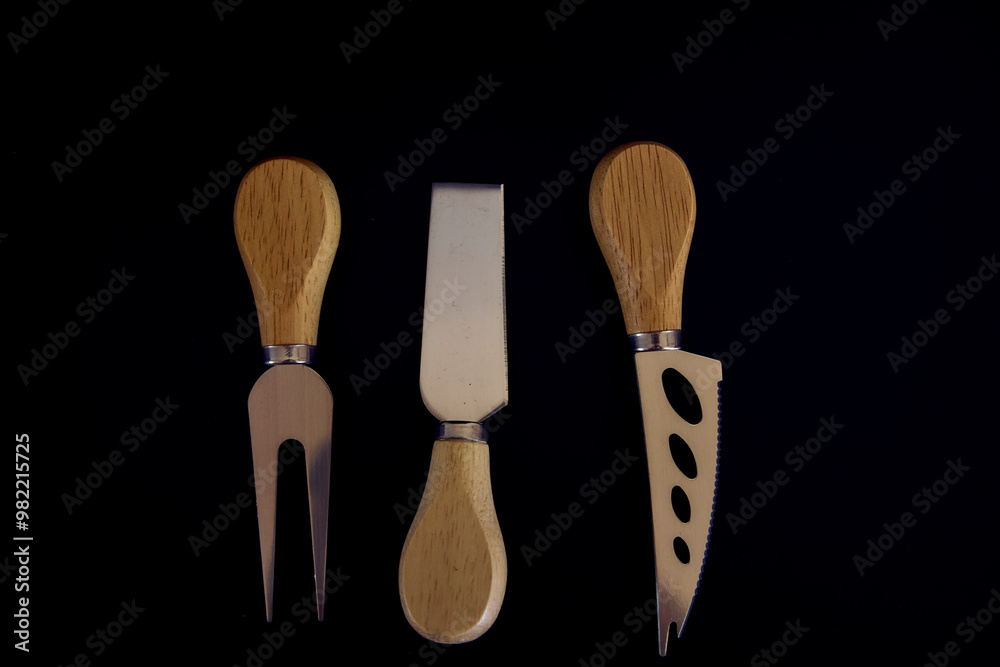 a set of fish and cheese knives with a wooden handle on a black background a set of fish and cheese knives with a wooden handle on a black background