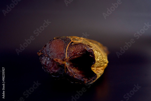 appetizing hot smoked golden horse mackerel on a black background photo