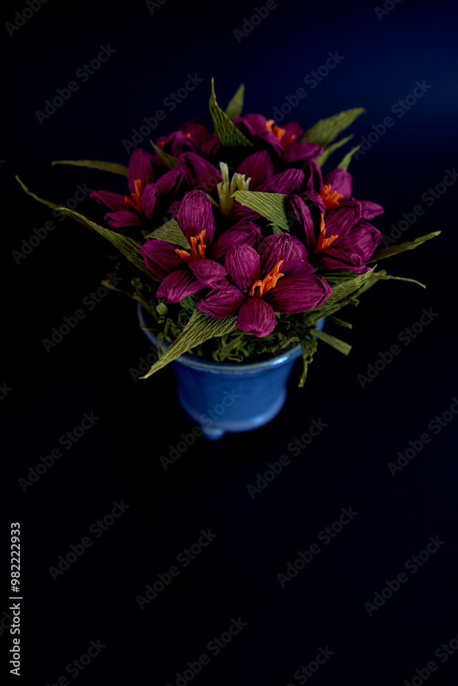 paper flowers in a blue vase on a black background paper flowers in a blue vase on a black background