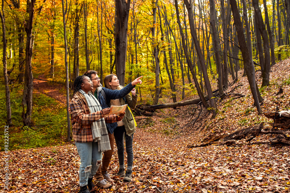 Three friends having fun and enjoying hiking in forest using map for direction. Three friends having fun and enjoying hiking in forest using map for direction.