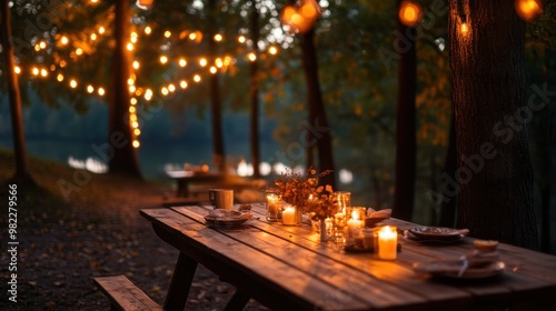 An autumn dinner table set outdoors under the trees, featuring warm lighting, candles, and seasonal dishes