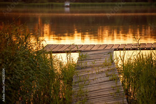 Wooden bridge on the lake at sunset photo