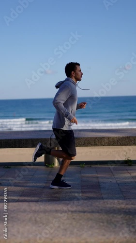 Young moroccan man training at the coastline. Athlete running outdoors.