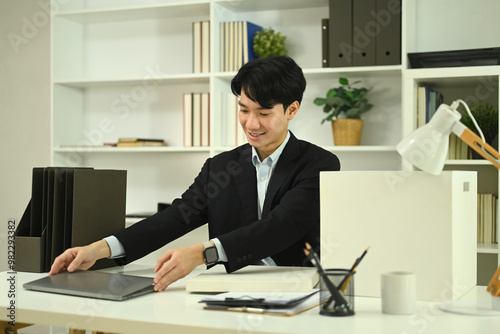 Handsome young businessman in formal suit working with laptop at office