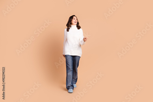 Photo of adorable cute senior woman wear white trendy clothes go empty space isolated on beige color background