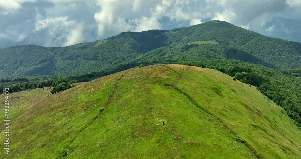 Flight over green mountain peaks. A beautiful sunny summer day at high altitude with thick clouds and the landscape in the background. Cinematic aerial video of nature in 4K Flight over green mountain peaks. A beautiful sunny summer day at high altitude with thick clouds and the landscape in the background. Cinematic aerial video of nature in 4K