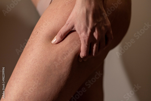 Close up of a woman pinching her thigh. Soft focus