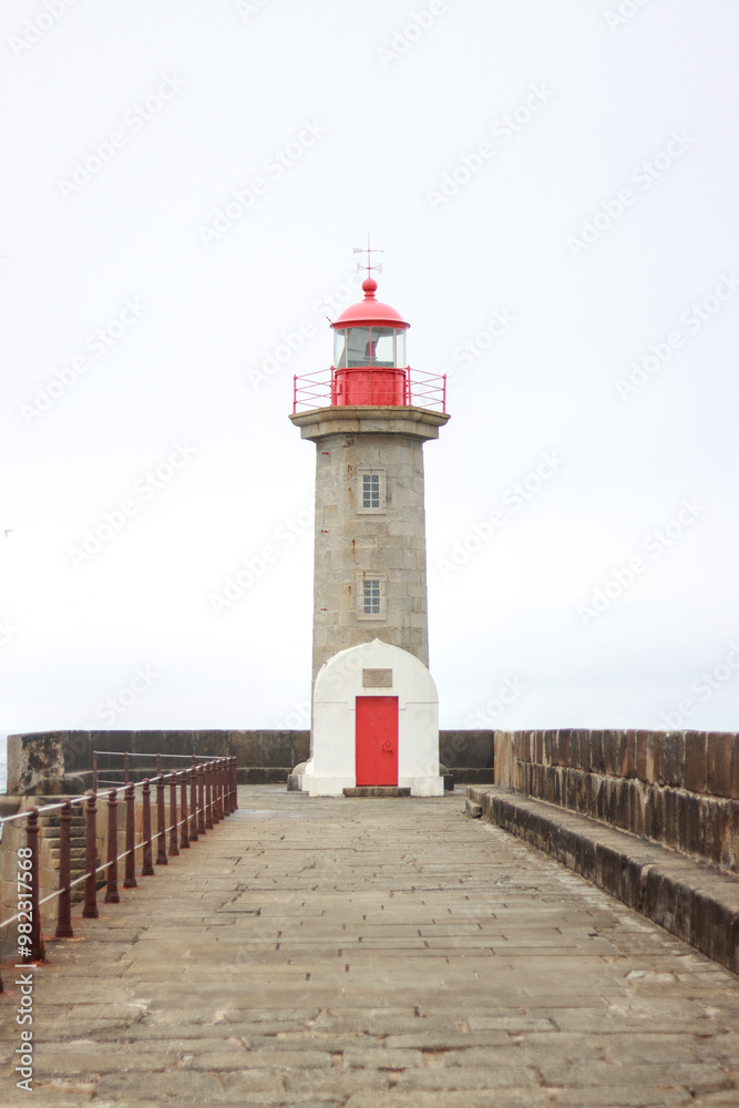 Red and white lighthouse on a pier with ocean view, vertical image Red and white lighthouse on a pier with ocean view, vertical image
