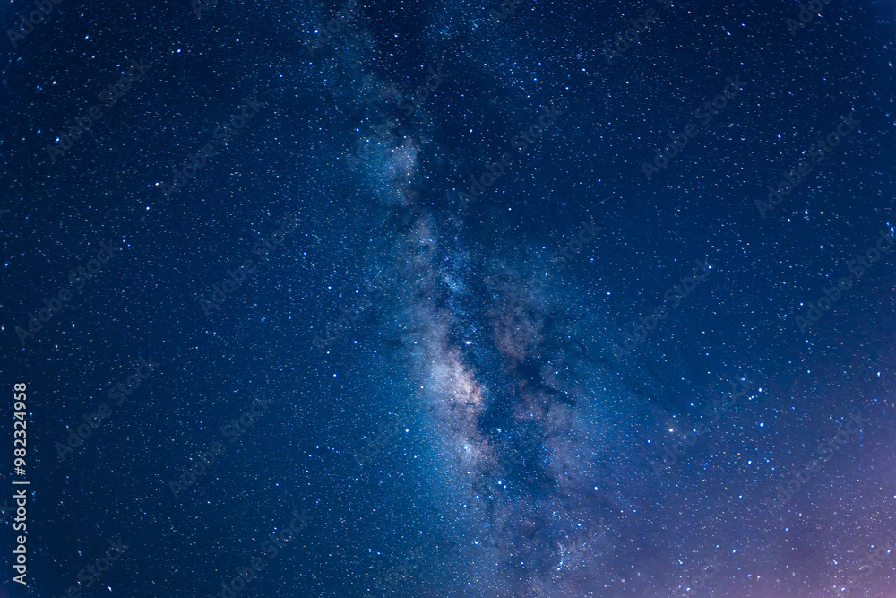 Obraz premium A breathtaking view of the Milky Way stretching across the night sky above a calm sea. The starry band of our galaxy is visible in all its glory. Suao, Yilan County, Taiwan.