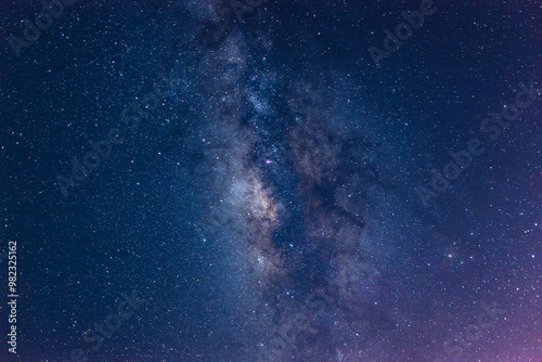 A breathtaking view of the Milky Way stretching across the night sky above a calm sea. The starry band of our galaxy is visible in all its glory. Suao, Yilan County, Taiwan.