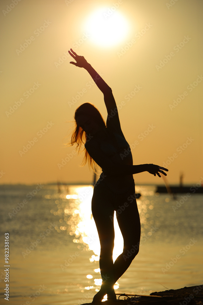 athletic woman in a bikini against the backdrop of a sunset athletic woman in a bikini against the backdrop of a sunset