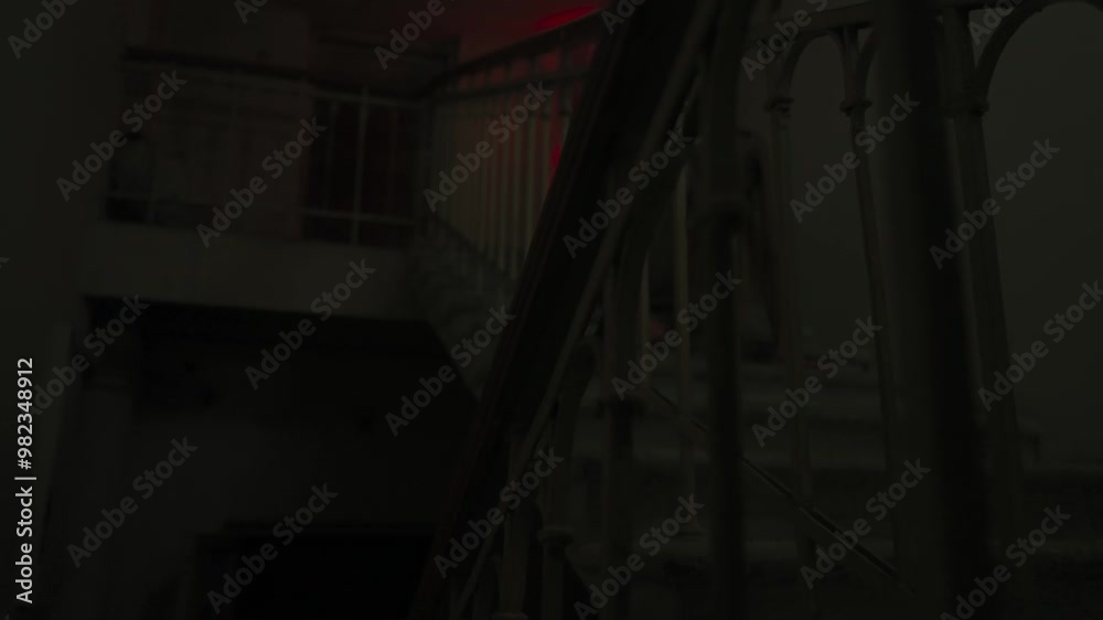 Creepy ghost woman in white dress and scary makeup alone crawling down the staircase in dark haunted house. Halloween horror advertisement concept. Creepy ghost woman in white dress and scary makeup alone crawling down the staircase in dark haunted house. Halloween horror advertisement concept.