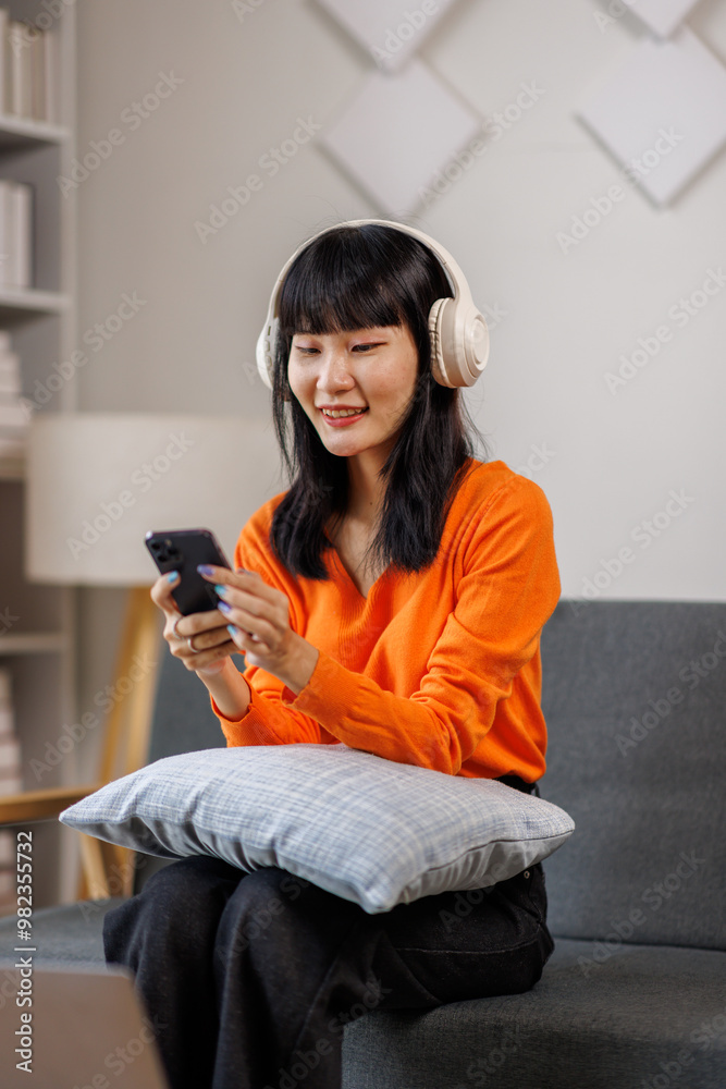 One caucasian woman asian female with headphones use mobile phone at home to listen to the music online happy smile sing joy have fun alone copy space One caucasian woman asian female with headphones use mobile phone at home to listen to the music online happy smile sing joy have fun alone copy space