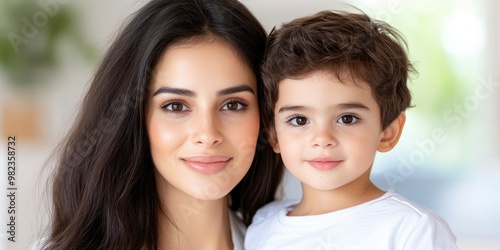 young mom and son smiling and looking at camera with blur background