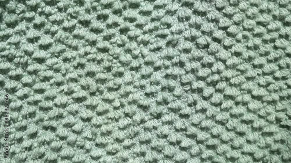 Soft green color cotton towel backdrop, fabric background. Terry cloth bath or beach towels. Macro. Slow motion. 