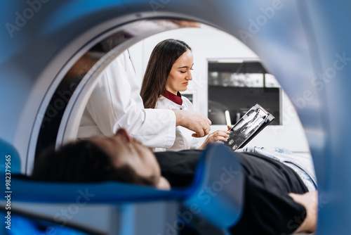 A patient undergoes an MRI or CT scan as doctors review images in a modern diagnostic center. This scene highlights the synergy between advanced technology and healthcare for accurate diagnoses. photo